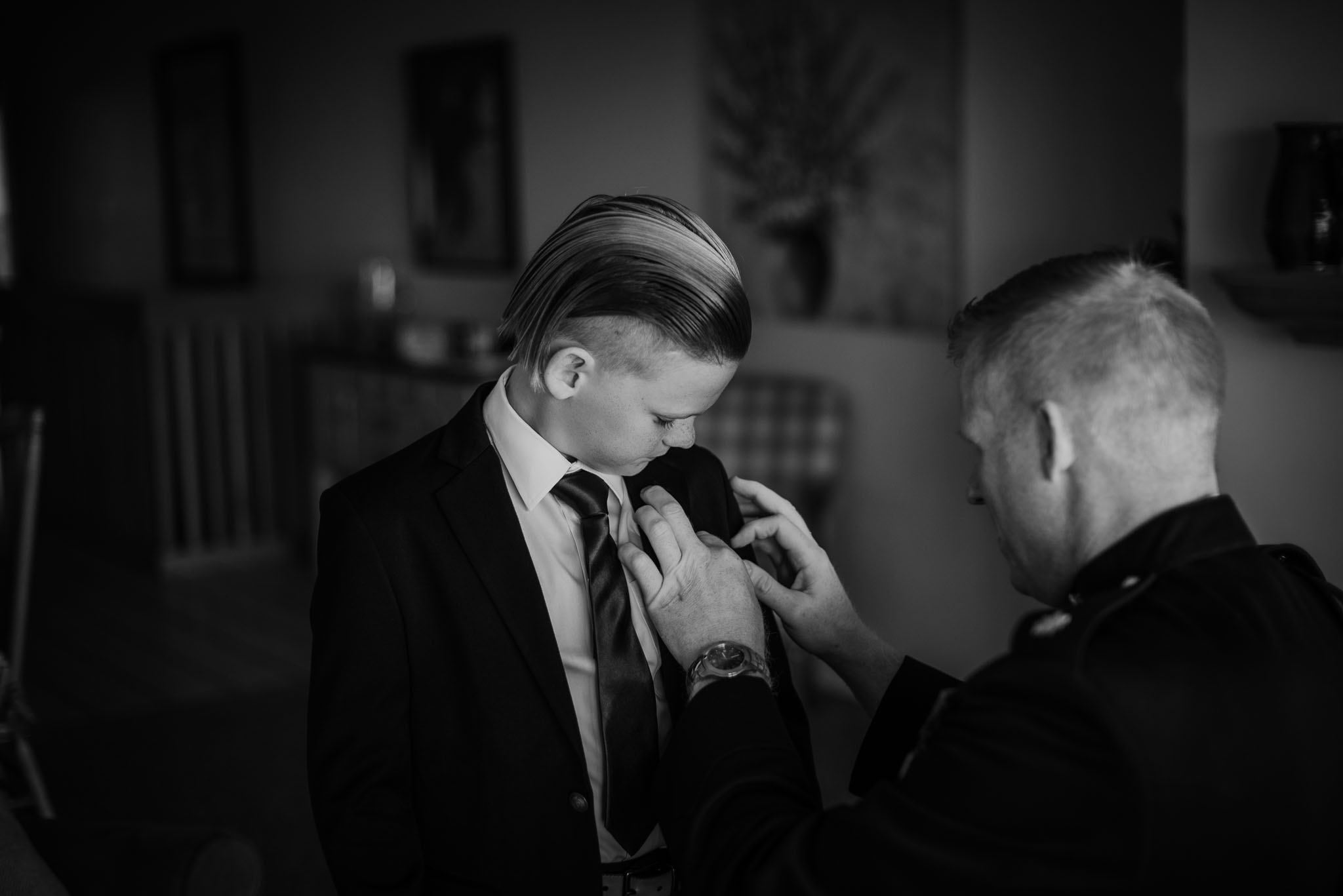 The groom helping his son with his boutonniere.
