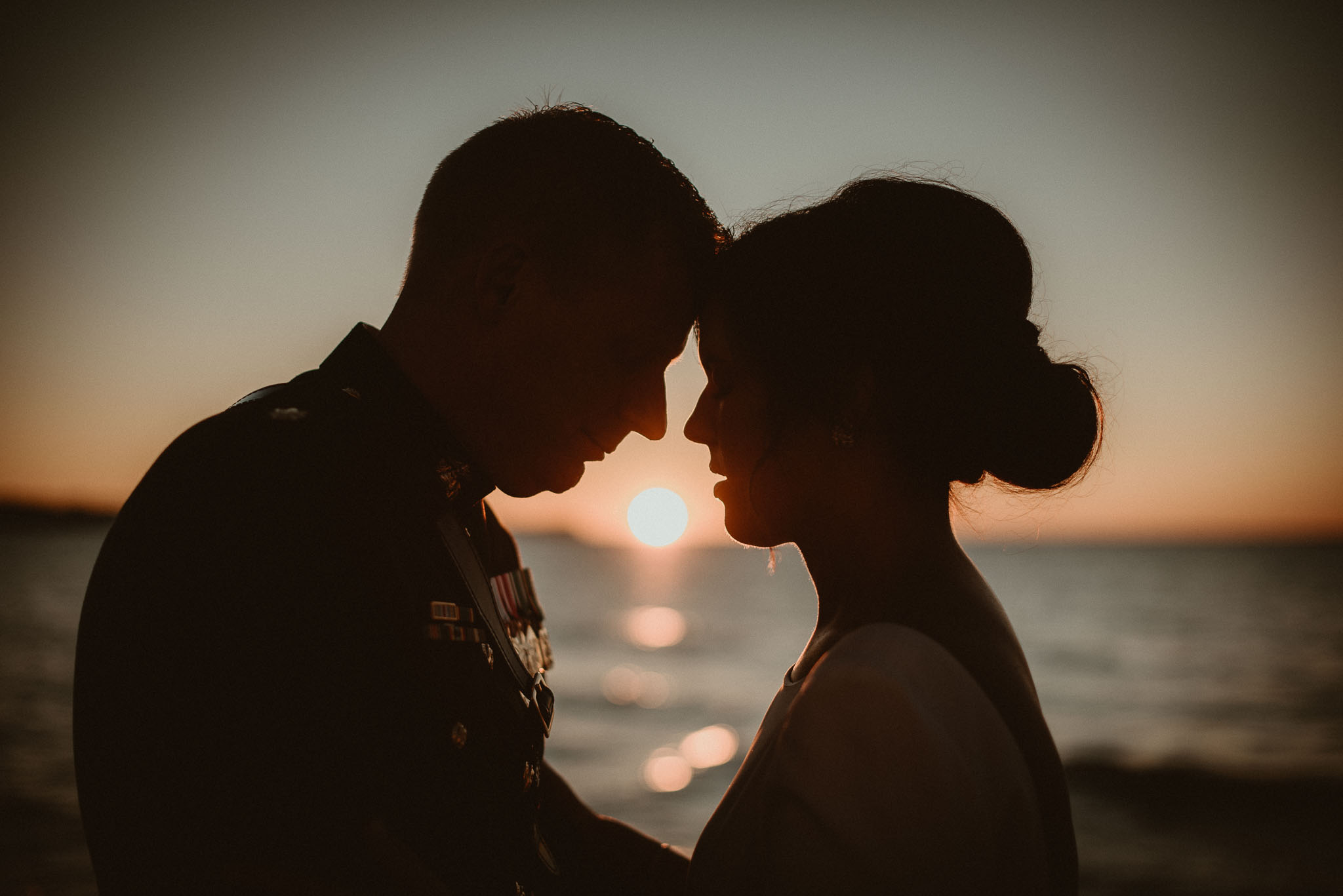Sunset between bride and groom in silhouette.