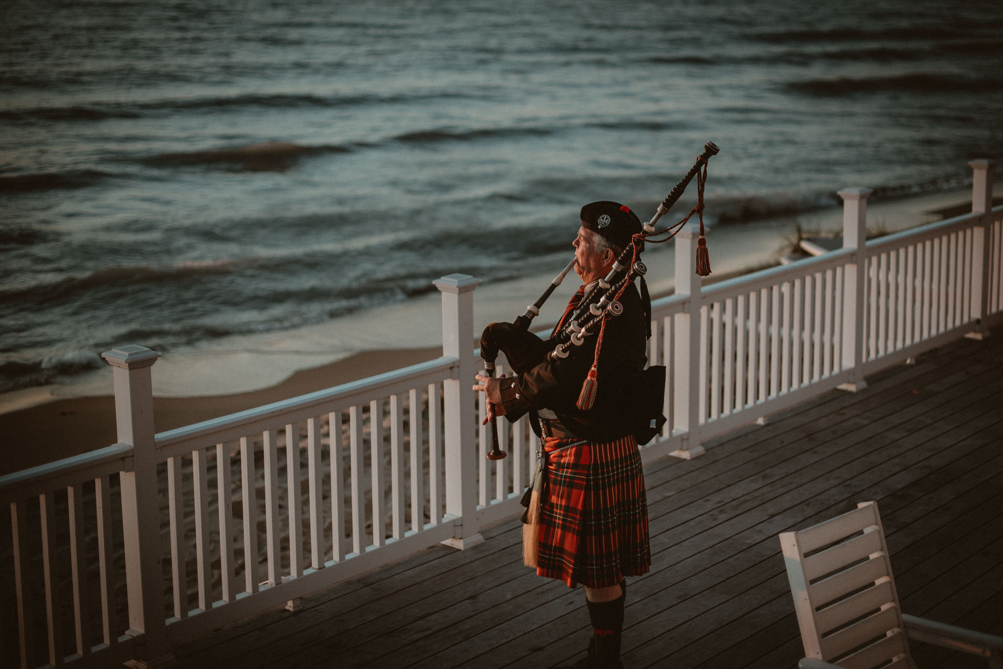 Bagpiper performing on the deck of Cafe Manitou at sunset on Lake Michigan