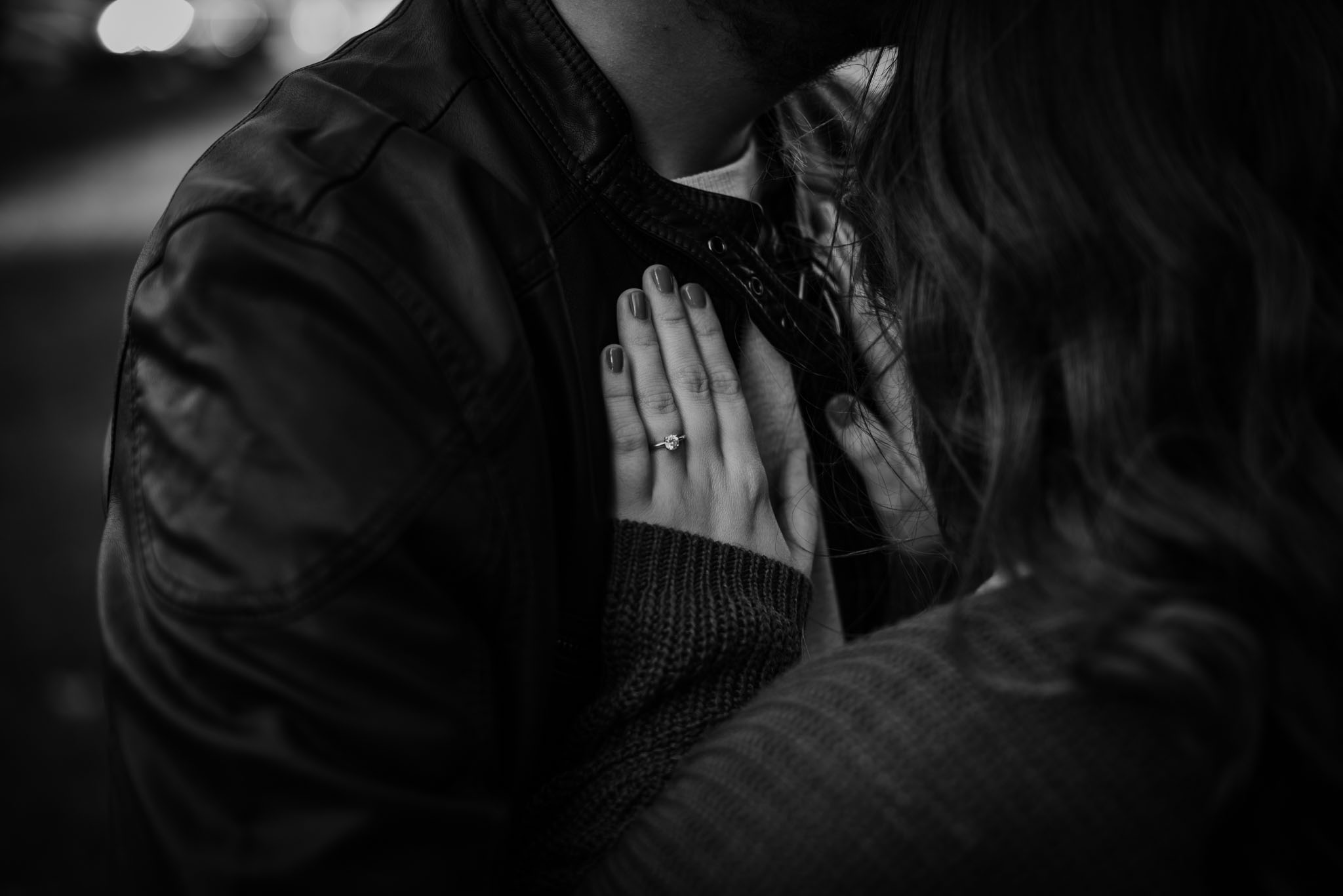 Engagement ring in black and white with her hand resting on his chest