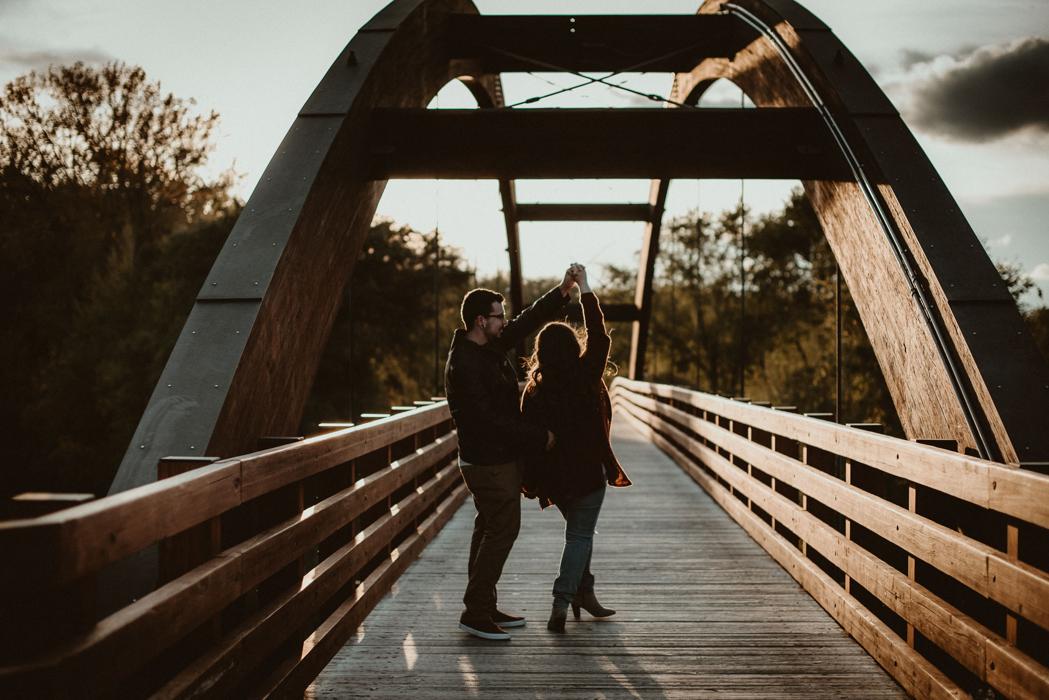 Twirling his fiance on the Tridge Bridge at sunset