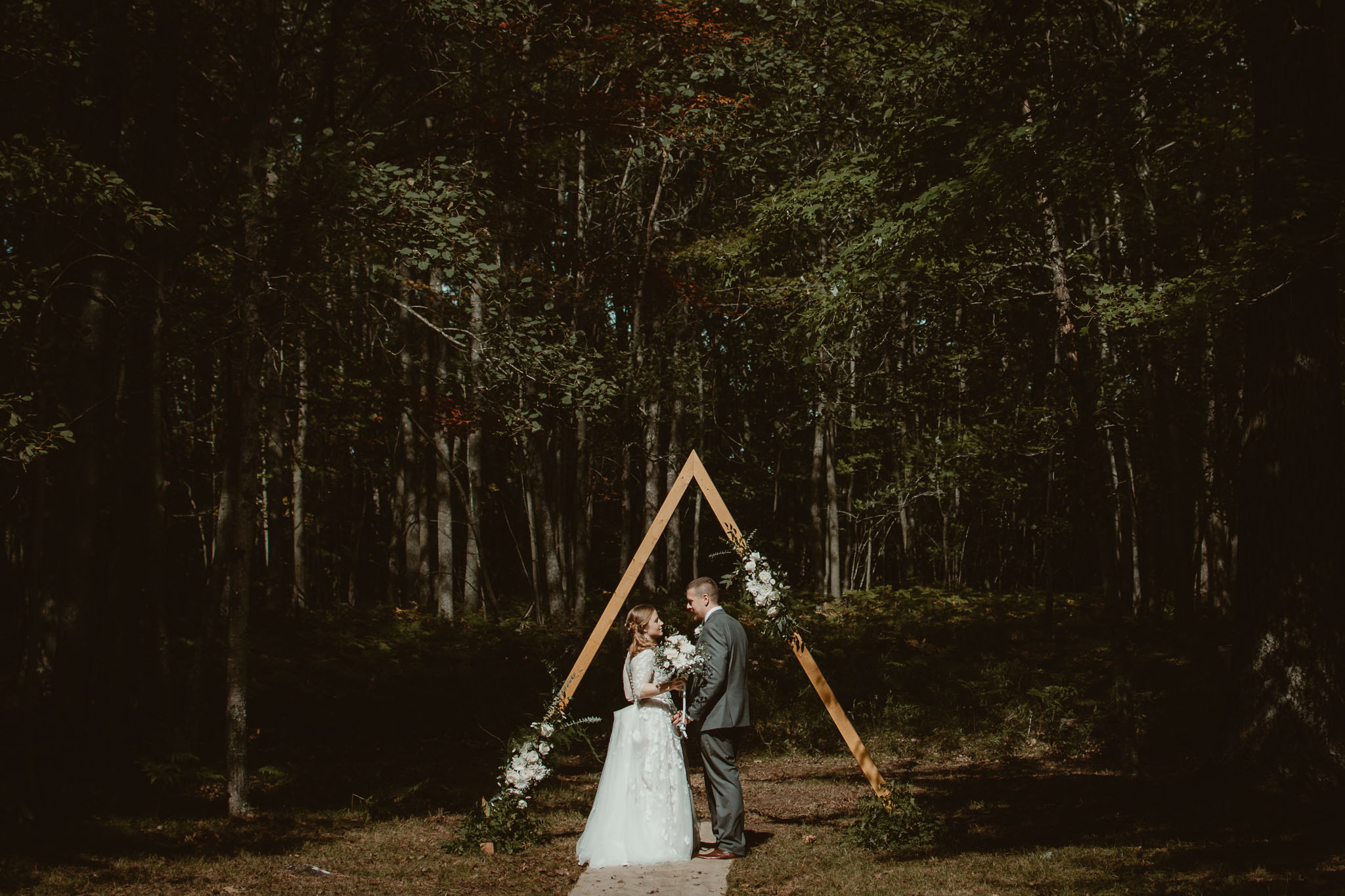 Bride and groom at triangle ceremony arch