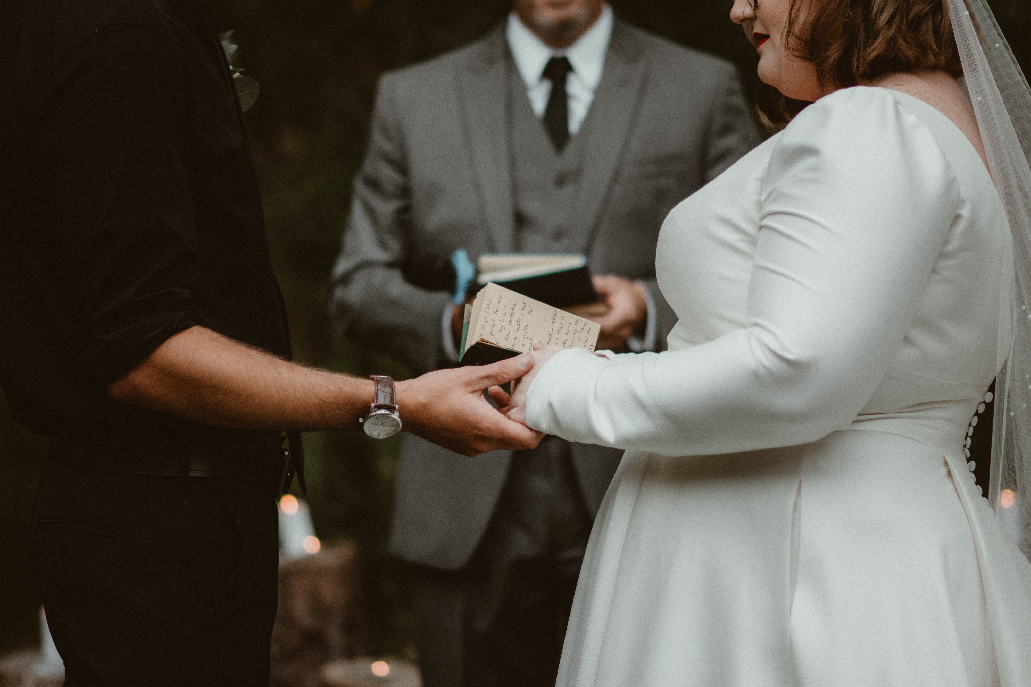 Bride and groom hands with hand written vows