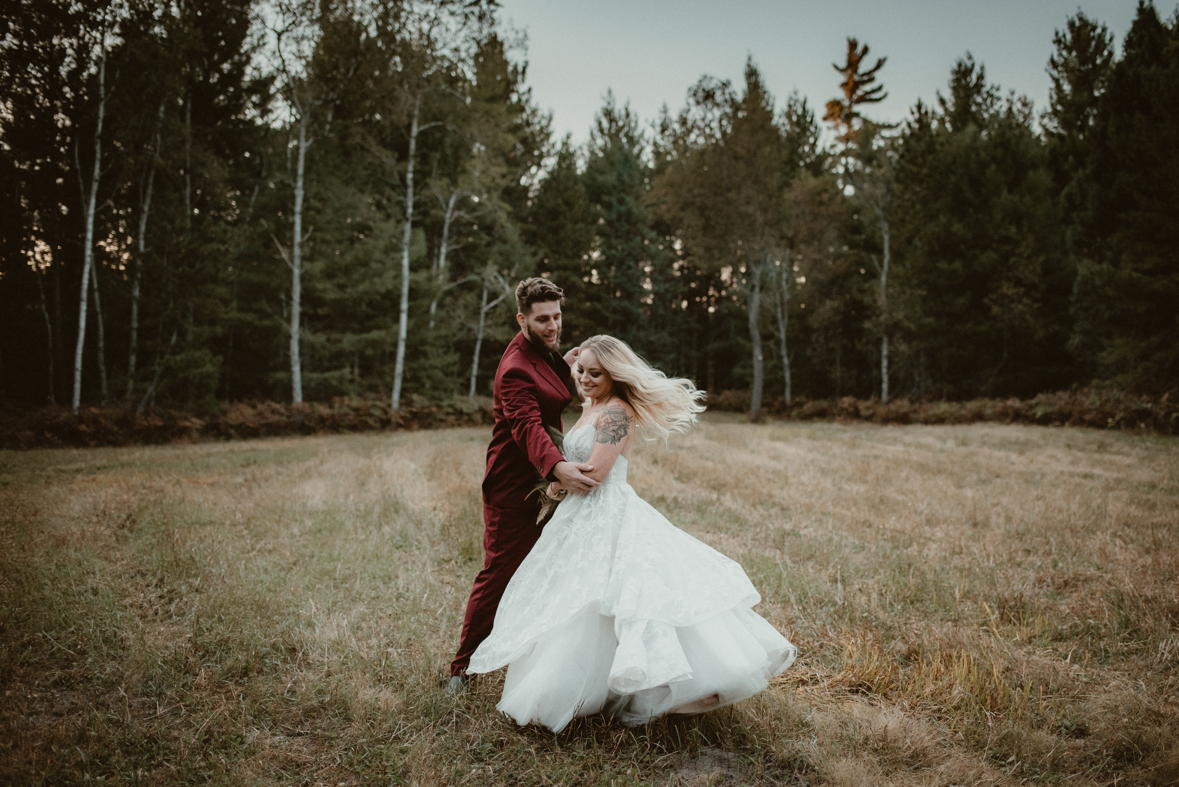 Sunset dance during wedding portraits. Couple in wedding attire dancing in the woods in Roscommon, MI