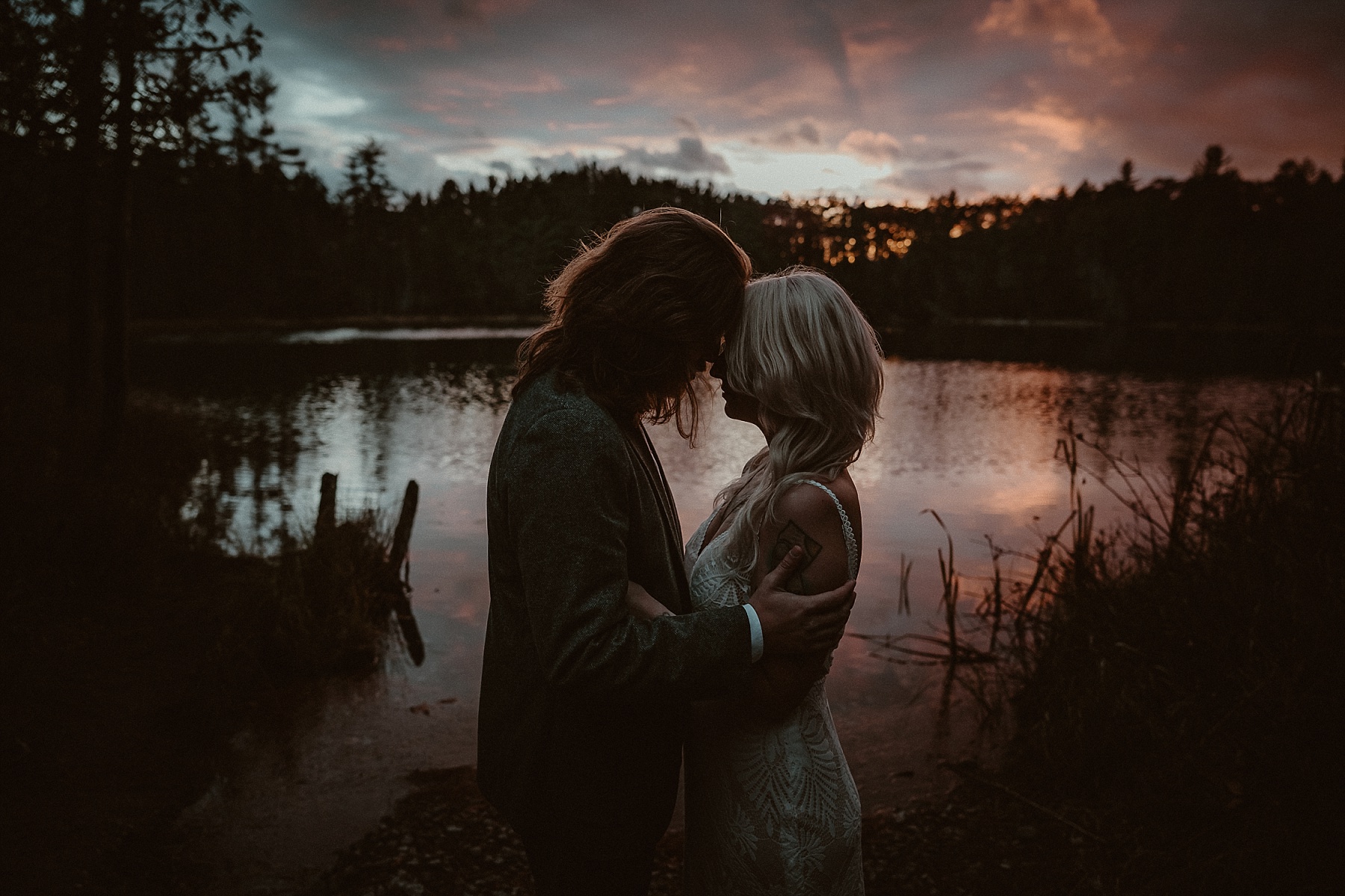 Bride and groom holding each other at sunset