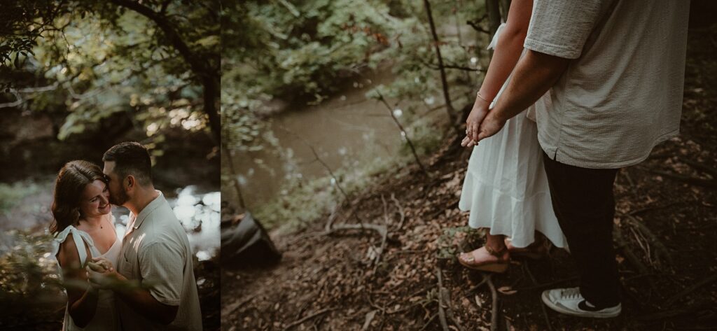 Couple standing near the edge overlooking the river holding hands and him kissing her cheek.