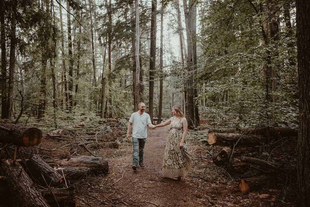 Couple playfully walking together in the woods.