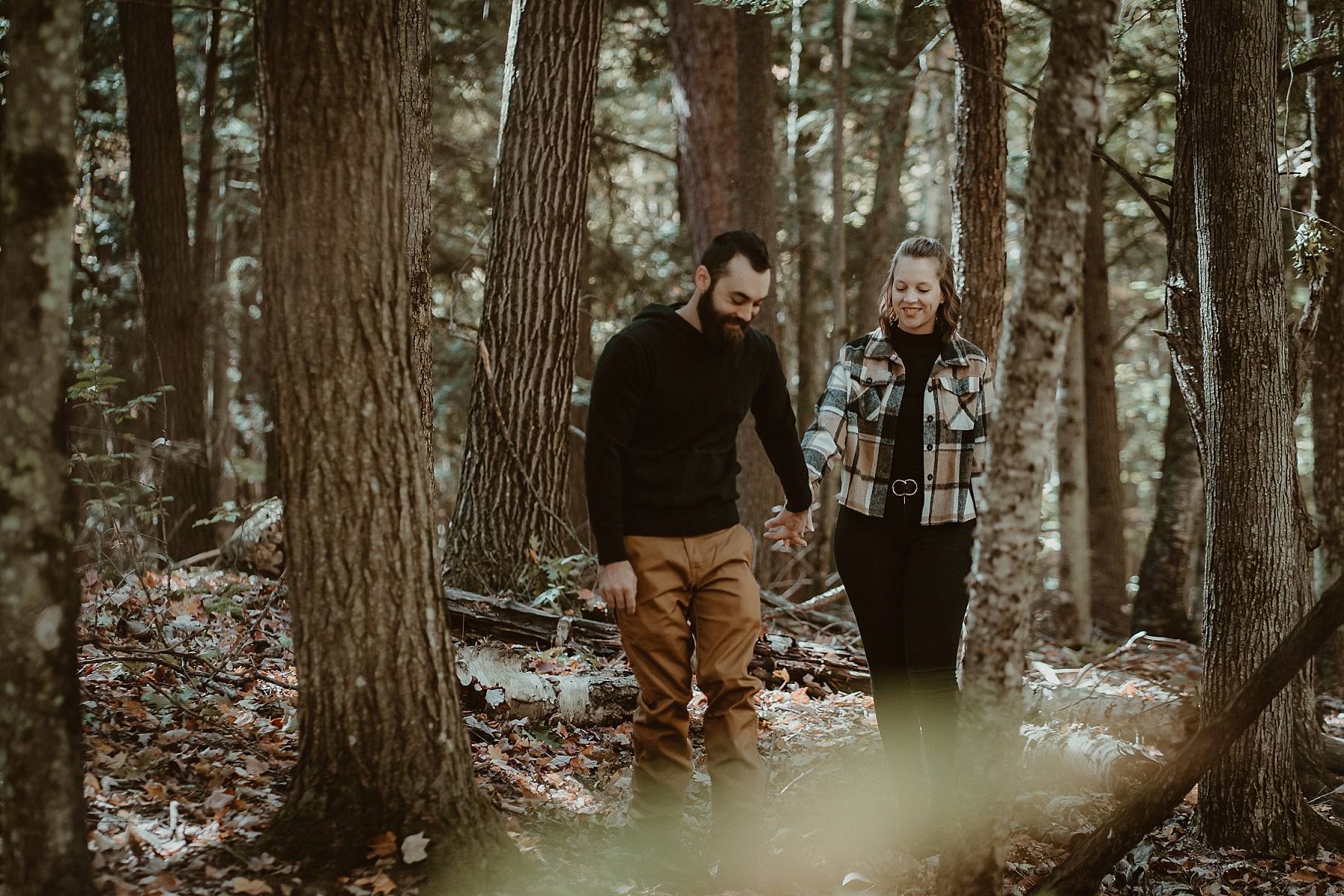 Couple walking through Hartwick Pines during peak fall color.