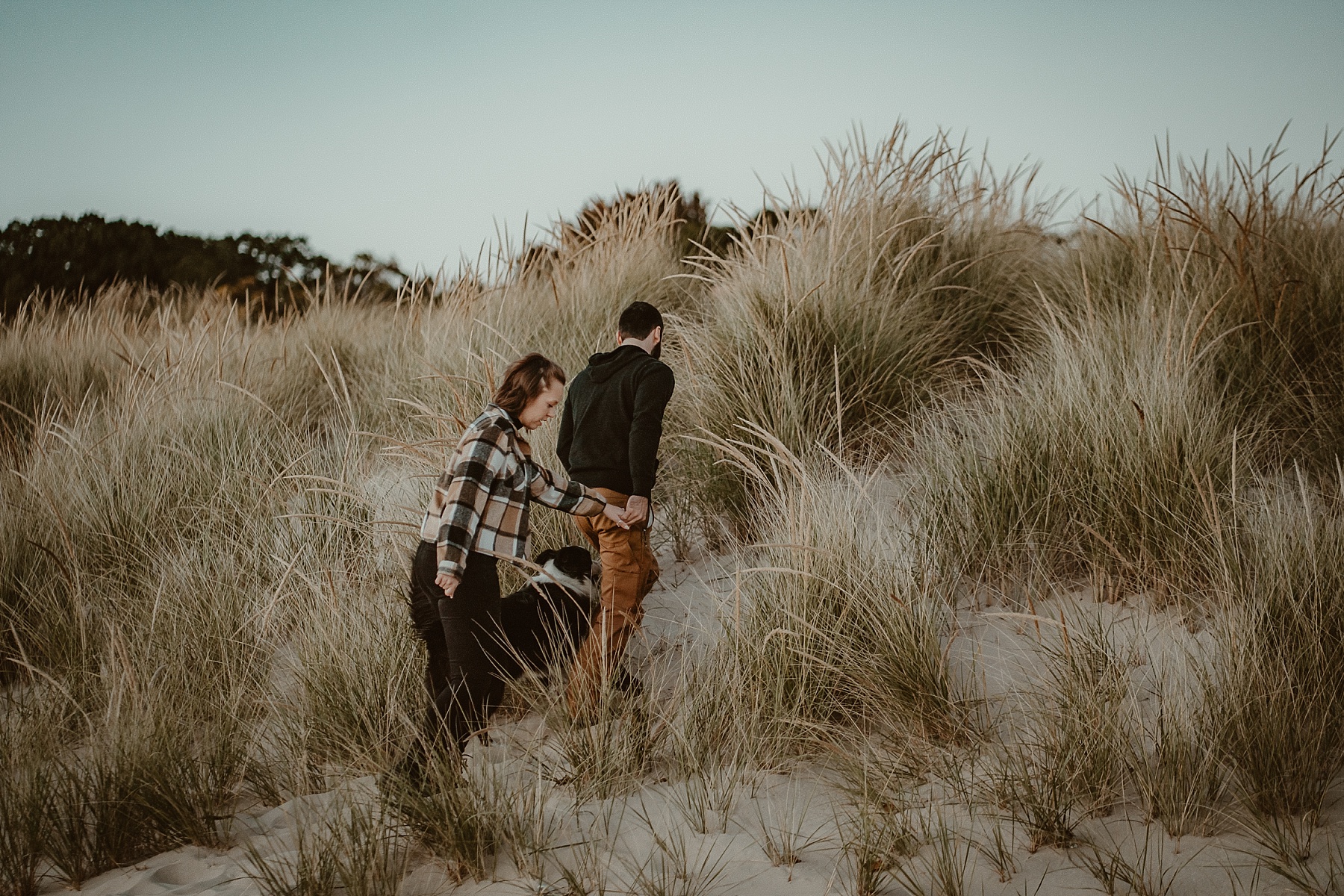 Couple walking up a small sand dune in Frankfort, MI