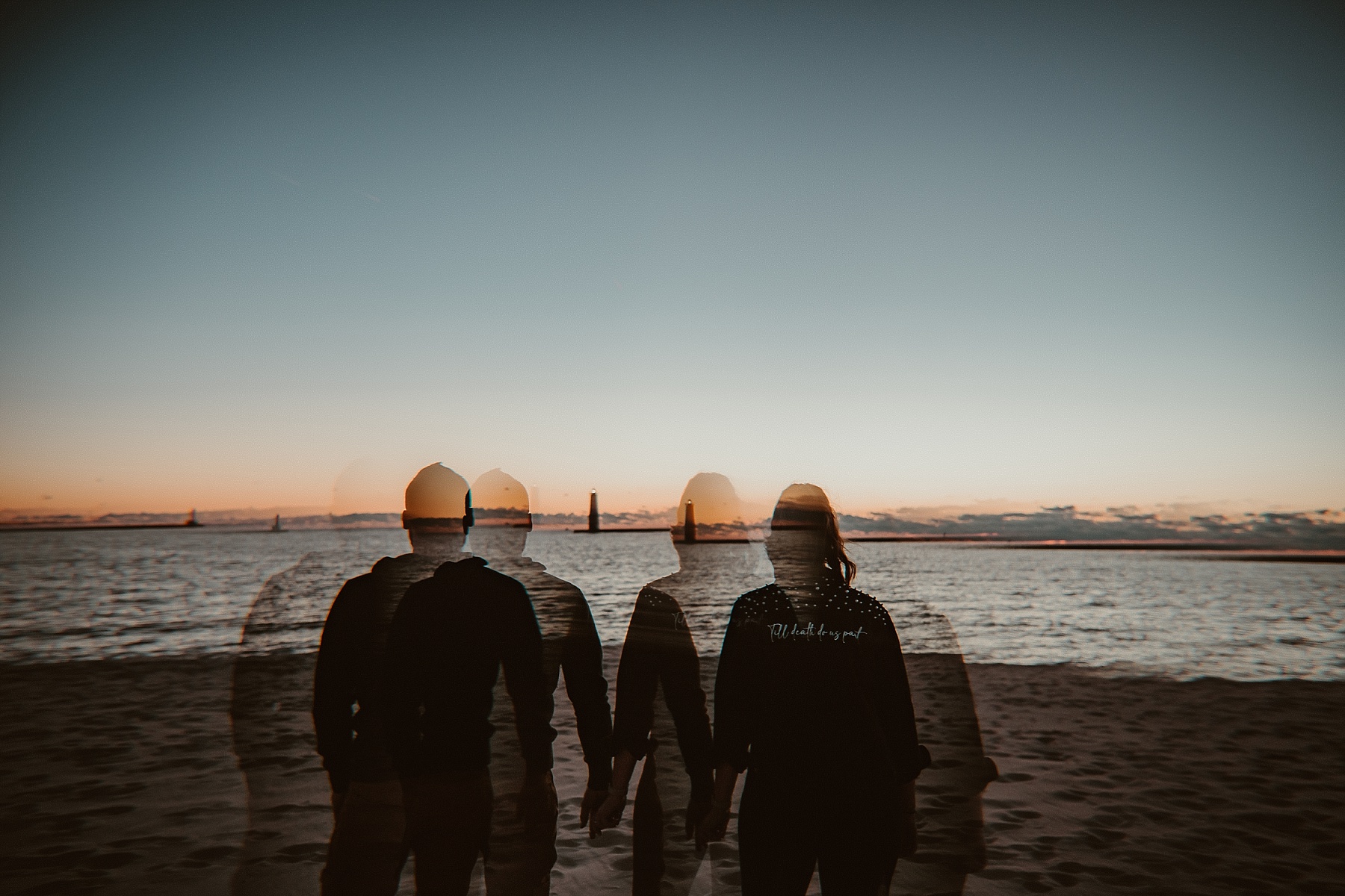 Creative ghosting of couple holding hands during a Lake Michigan sunset.