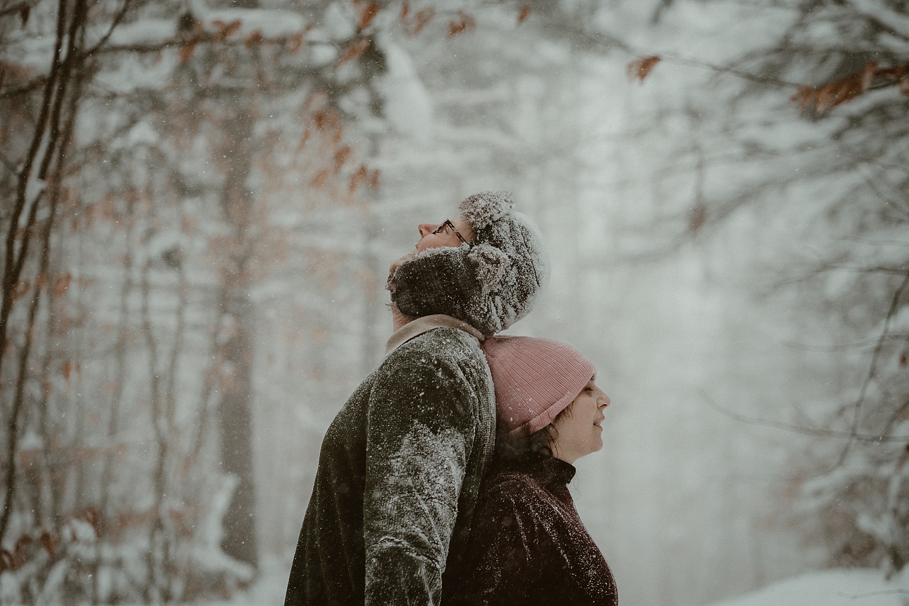 Winter engagement photos in Hartwick Pines State Park during a Michigan snowstorm.