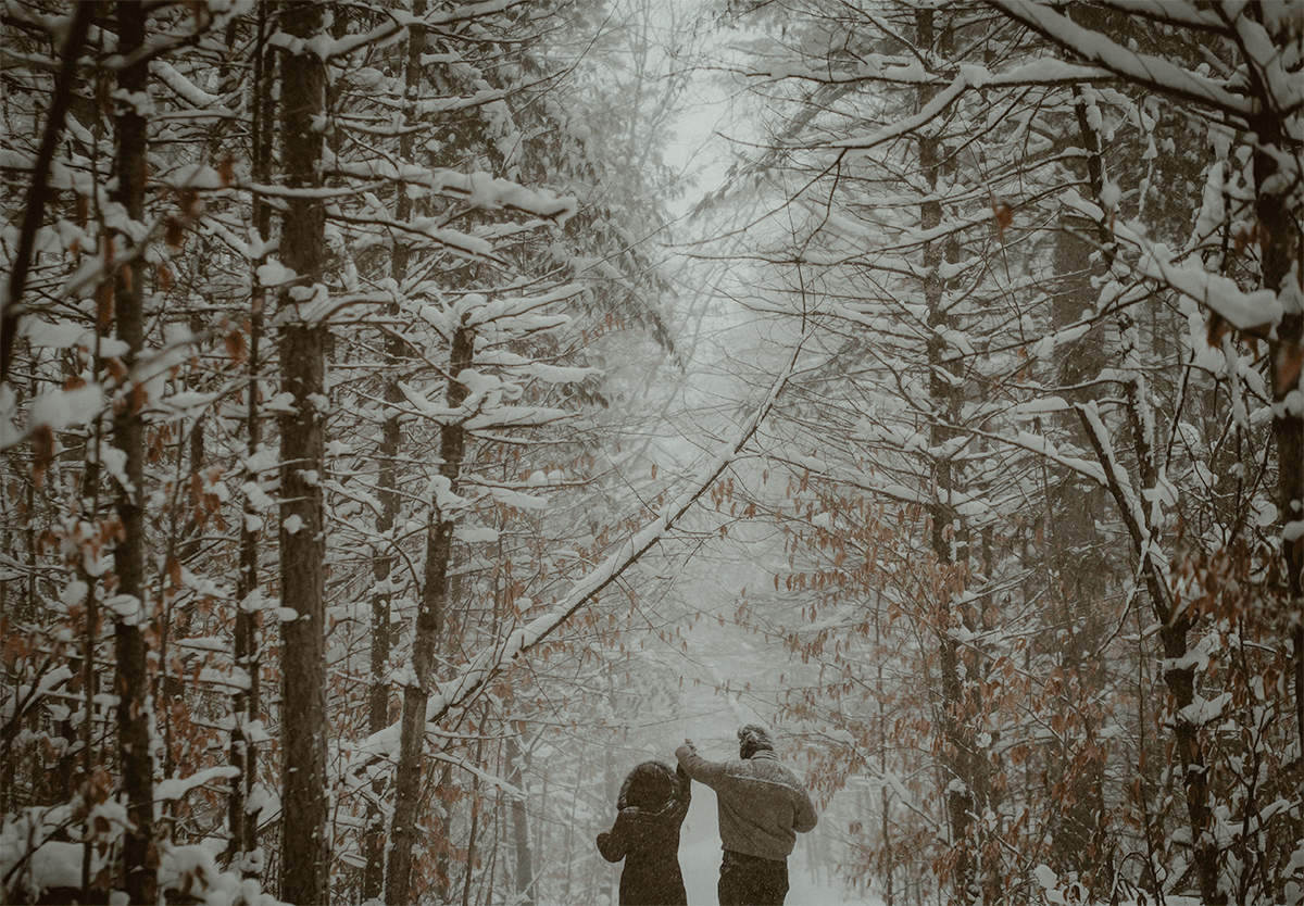 GIF of couple dancing the heavy snow fall during engagement session at Hartwick Pines State Park in Grayling MI
