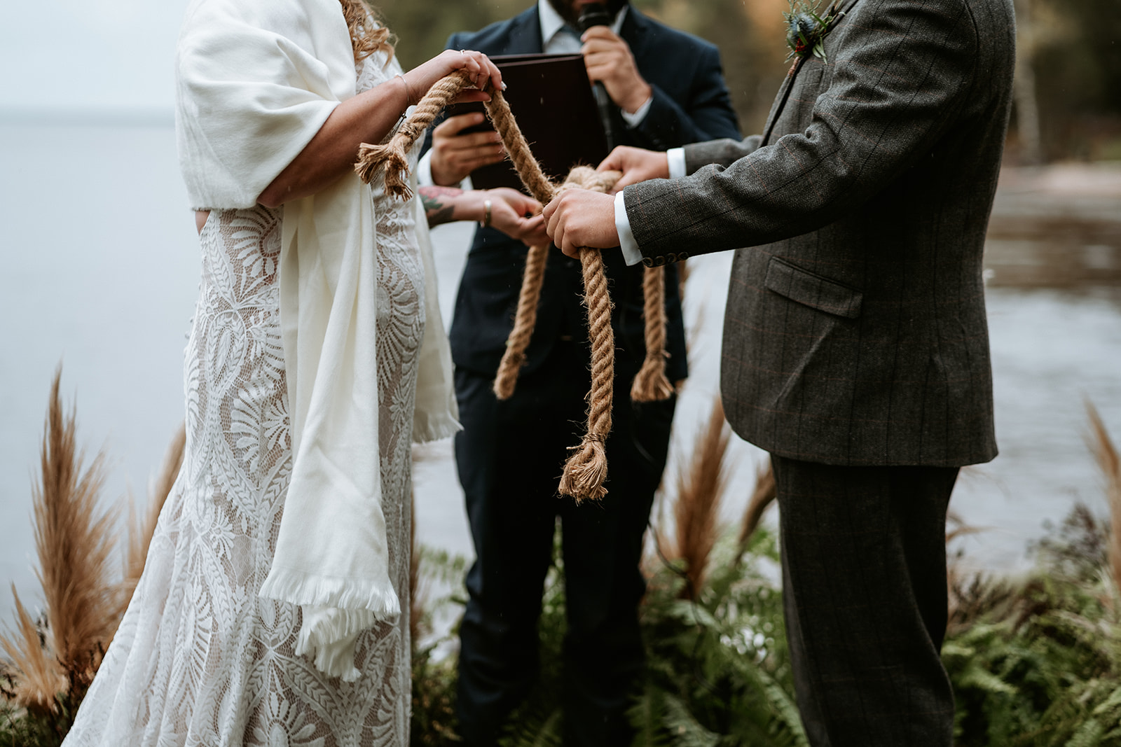 Couple tying the knot with ropes for their Lake Superior elopement.