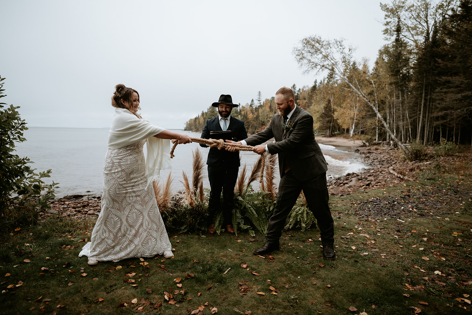 Couple pulling on the knot they tied together during their ceremony on Lake Superior, Michigan.